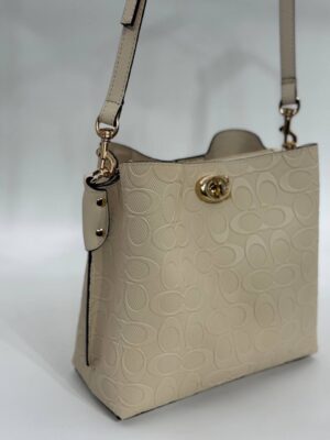 Coach Gofraj baskılı kilitli büzgülü bej çanta